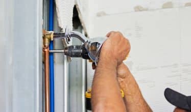 plumber working on bathroom shower plumbing